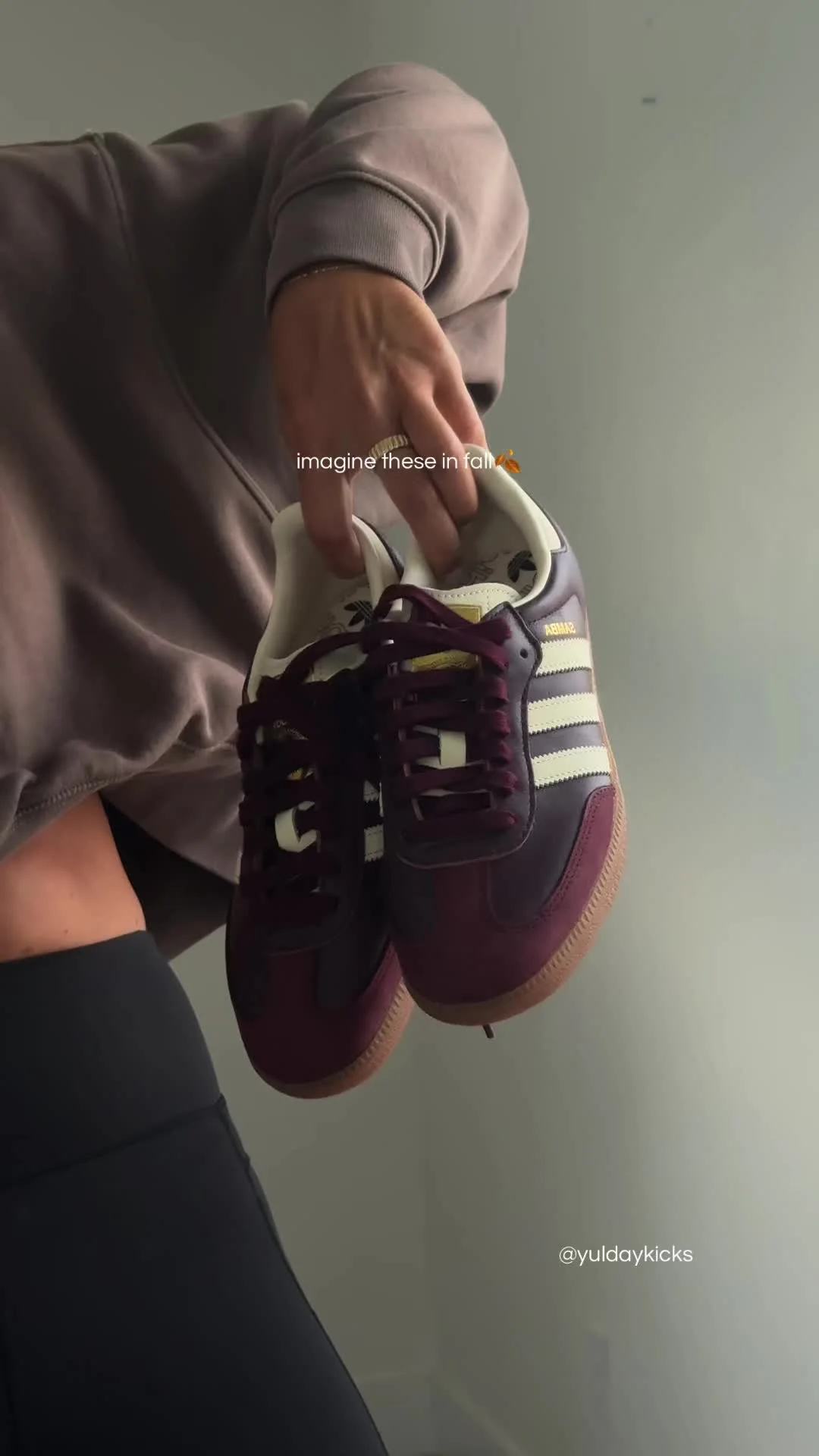 Maroon Adidas Spezial held up by Yul Day